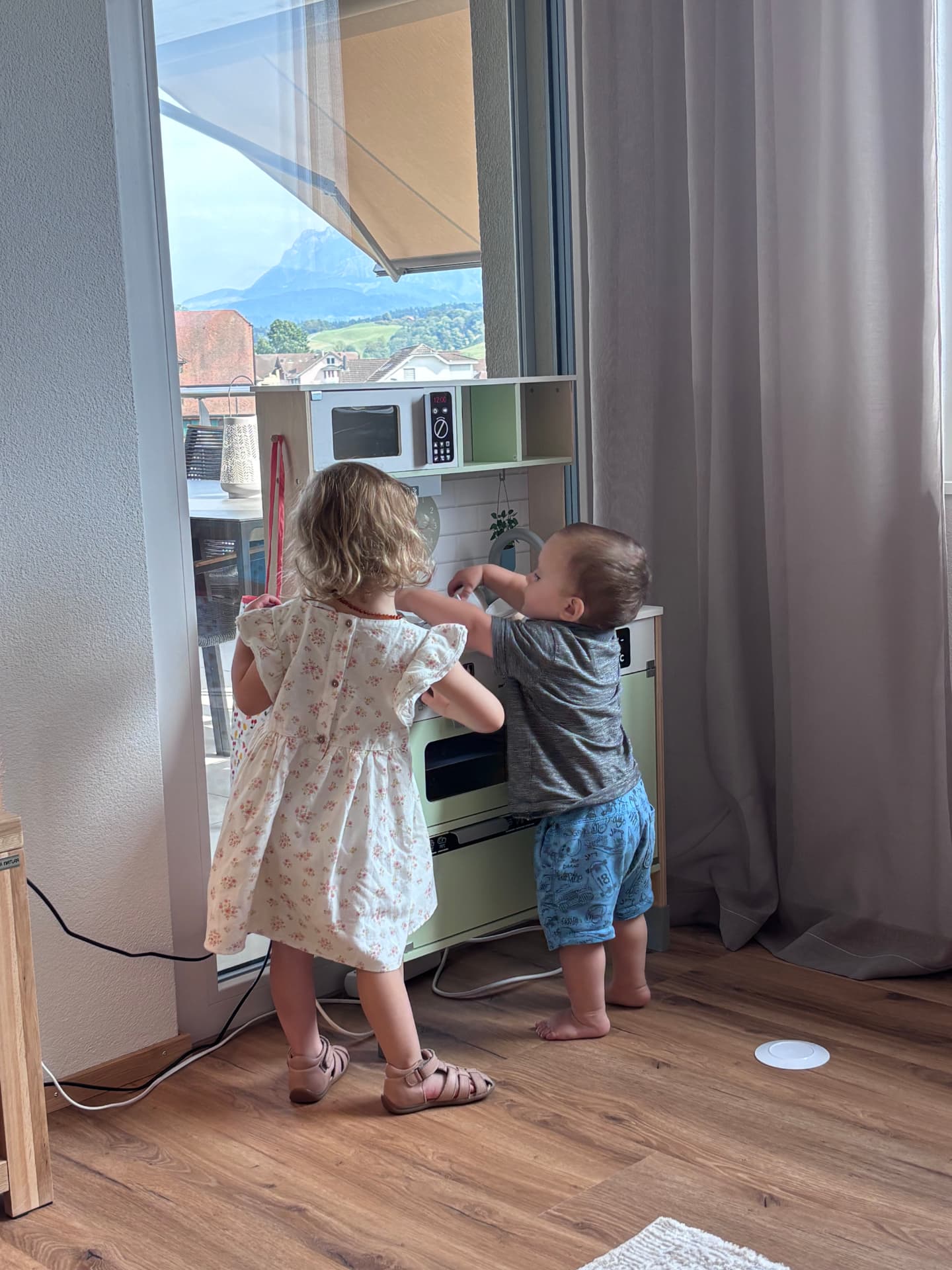 Zwei Kinder spielen mit einer Spielküche in der Spielecke der Ferienwohnung in Ruswil